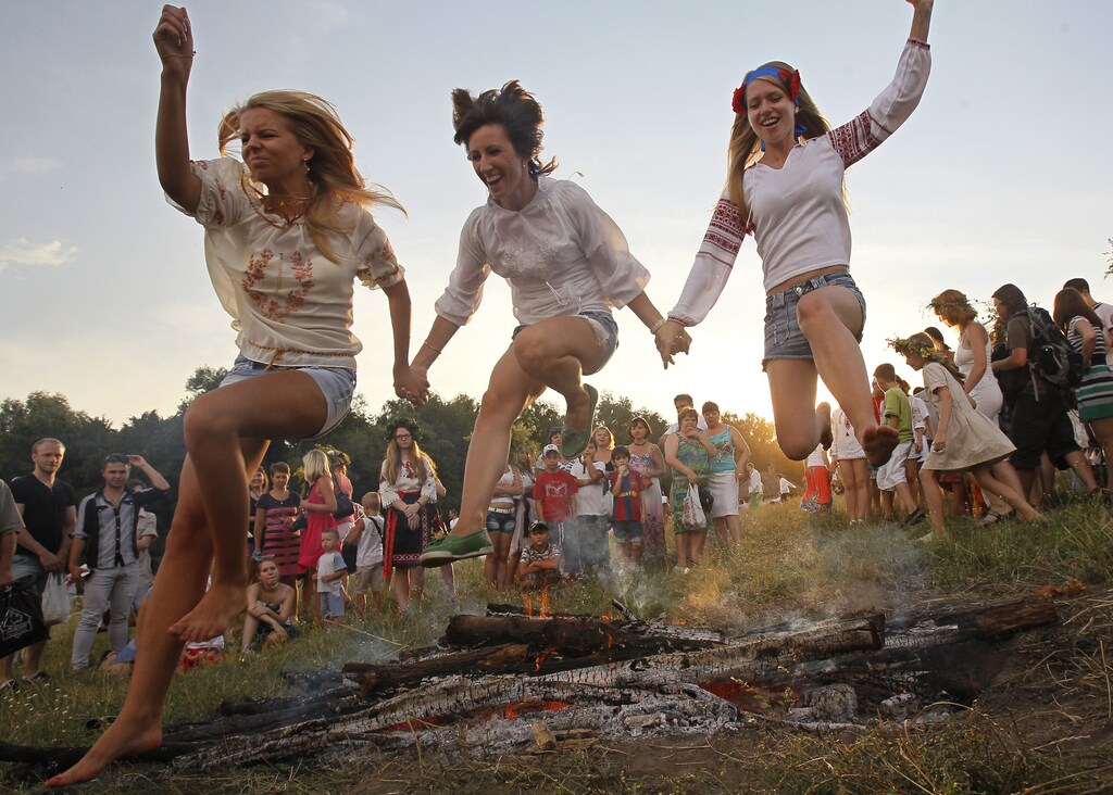 People jump over a campfire during a celebration of the traditional Ivana Kupala (Ivan the Bather) holiday near Kiev.