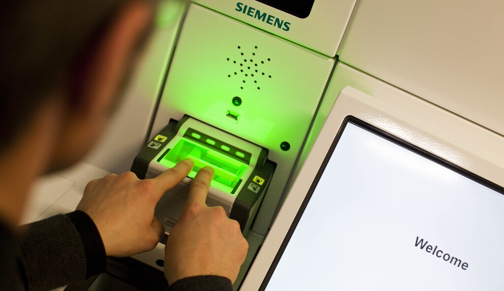 A man demonstrates the issuing of the new Swiss biometric passport at the Office of Passport Services in Zurich, January 26, 2010.