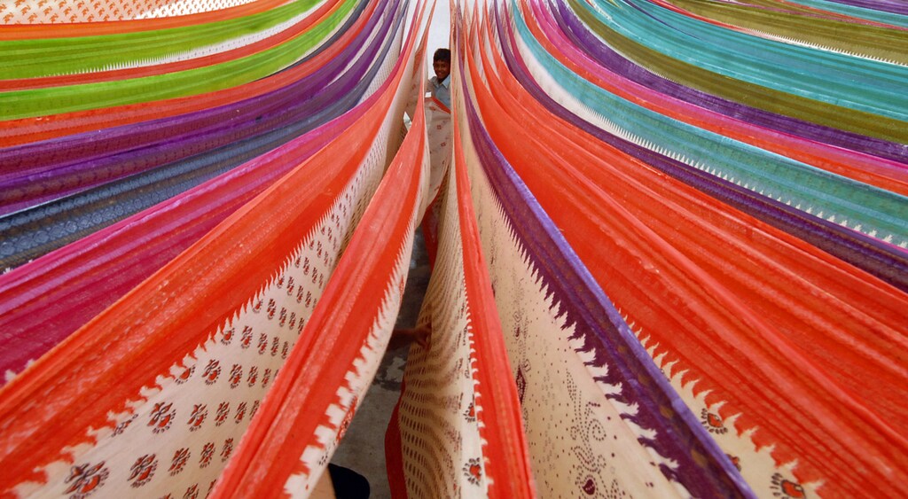 A child plays among sarees at a cotton saree factory in the outskirts of Hyderabad