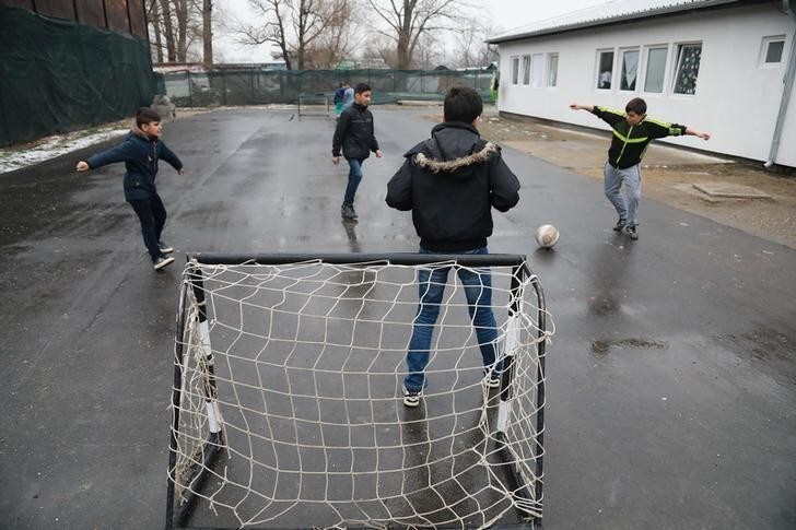 Kids play football inside the camp for refugees and migrants in the Belgrade suburb of Krnjaca, Serbia, January 16, 2018. Picture taken January 16, 2018 REUTERS/Djordje Kojadinovic