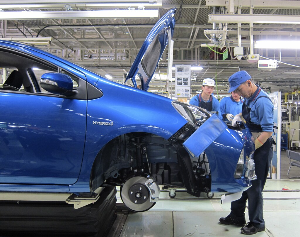 An assembly line worker attaches the bumper onto the body of a Toyota Aqua, the world's cheapest and most fuel-efficient conventional hybrid car, at a factory of the automaker's subsidiary in Japan.