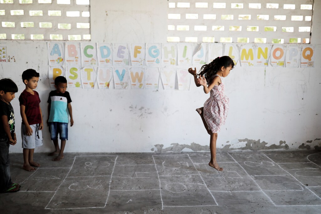 (L-R) Adriel, 6, Matheus 6, and Rian, 5, look at her classmate Michelly as they play during class at Sao Jose school in Morro Do Veridiano, Belagua Municipality, Maranhao state, Brazil, October 10, 2018. Picture taken October 10, 2018. According to the 2015 National Household Sample Survey (Pnad), 2.8 million children and adolescents aged 4 to 17 are out of school. More than half (53 percent) come from households whose income per capita does not exceed half the minimum wage, a value of 477 reais (~$123 USD). While Brazil is in the top ten economies in the world, there are still millions of people in the northeast of the country who are in extreme poverty. REUTERS/Nacho Doce TPX IMAGES OF THE DAY - RC19675F85D0