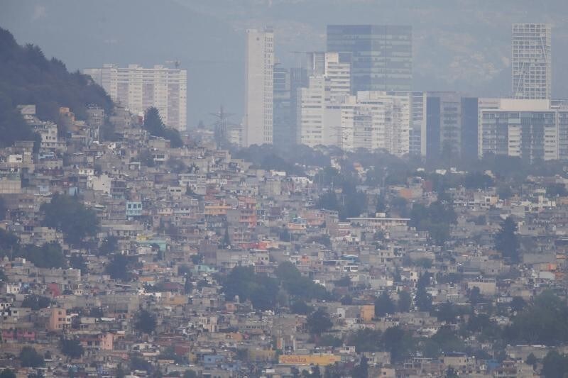 Buildings and houses stand shrouded in smog in Mexico City, March 16, 2016. Mexico City's government ordered traffic restrictions and recommended people stay indoors due to serious air pollution, issuing its second-highest alert warning for ozone levels for the first time in 13 years.