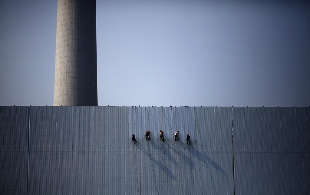 Workers paint an exterior wall of a power plant in Beijing, July 15, 2014. China's leaders are expecting to see a dividend from three months of stimulus spending in second-quarter growth data on July 16, 2014, but the economy may need even more state support to meet this year's growth target of 7.5 percent. Picture taken July 15, 2014. REUTERS/Kim Kyung-Hoon (CHINA - Tags: BUSINESS ENERGY POLITICS EMPLOYMENT TPX IMAGES OF THE DAY) - GM1EA7G00Y101
