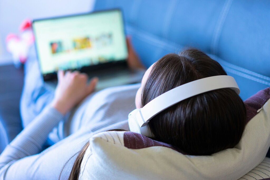 Person with headphones looking at laptop screen