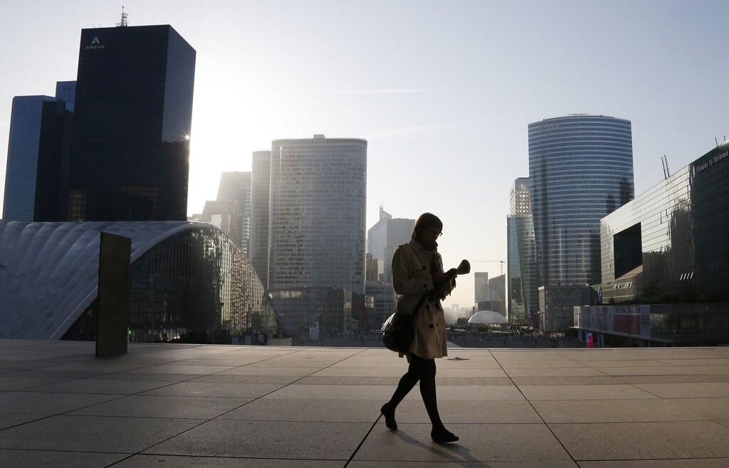 A woman walks on the esplanade of La Defense, in the financial and business district in La Defense, west of Paris, April 10, 2014.