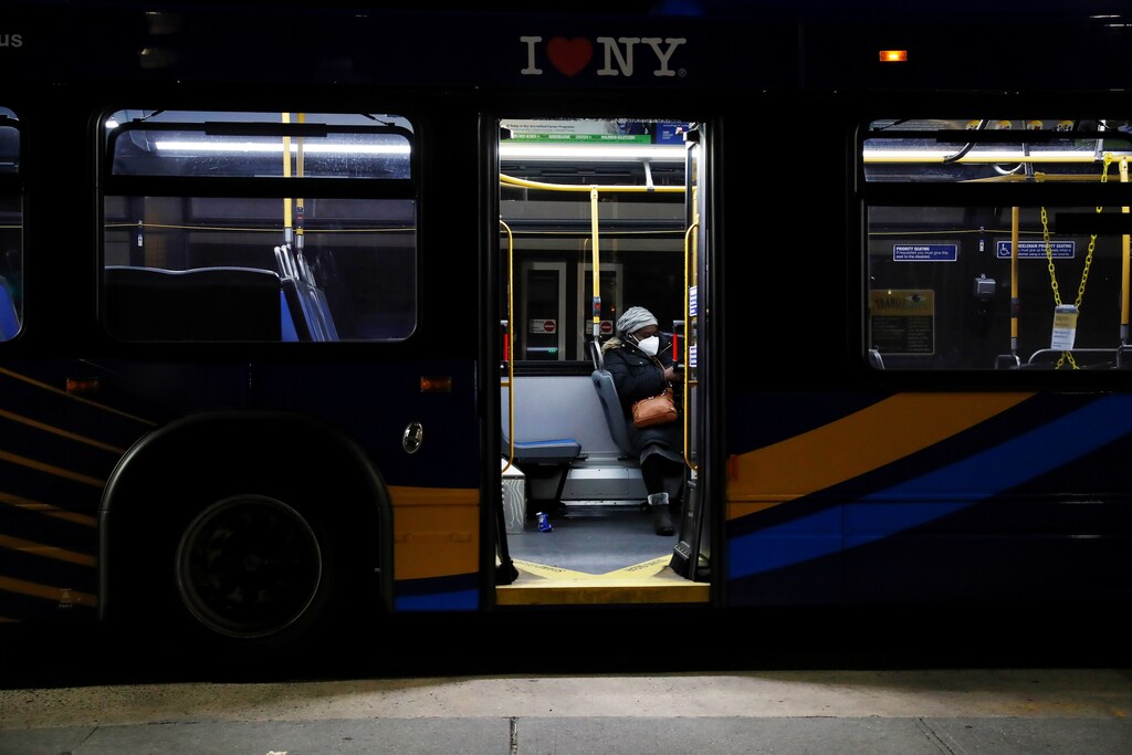 A woman sits with a protective face mask on an empty bus as the coronavirus disease (COVID-19) continues, in the Queens borough of New York, U.S., May 10, 2020. REUTERS/Shannon Stapleton - RC21MG93PN59