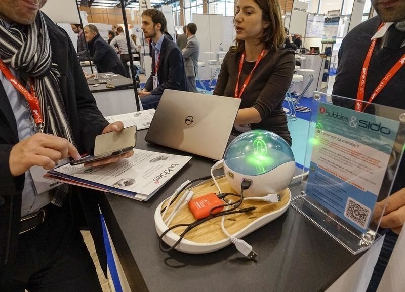 Visitors look at Bubbles, a connected device, presented at the SIdO, the Connected Business trade show in Lyon April 7, 2015. The new professional event dedicated to the Internet of Things (IoT) takes place in Lyon on April 7 and 8.