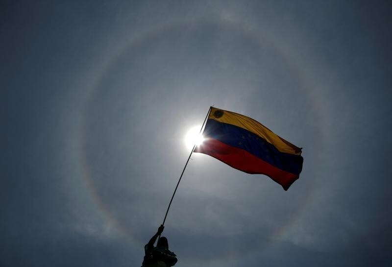 An opposition supporter holds a Venezuelan flag during a rally against the government of Venezuela's President Nicolas Maduro and to commemorate May Day in Caracas Venezuela, May 1, 2019. REUTERS/Ueslei Marcelino - RC1FCEF66C20