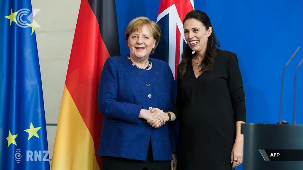New Zealand's Jacinda Ardern and Germany's Angela Merkel are seen shaking hands.