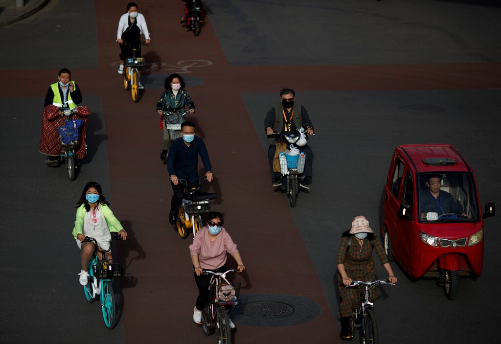 La gente usa protección durante la hora punta de la tarde después de la propagación de la nueva enfermedad coronavirus (COVID-19) en Beijing, China, el 12 de mayo de 2020.