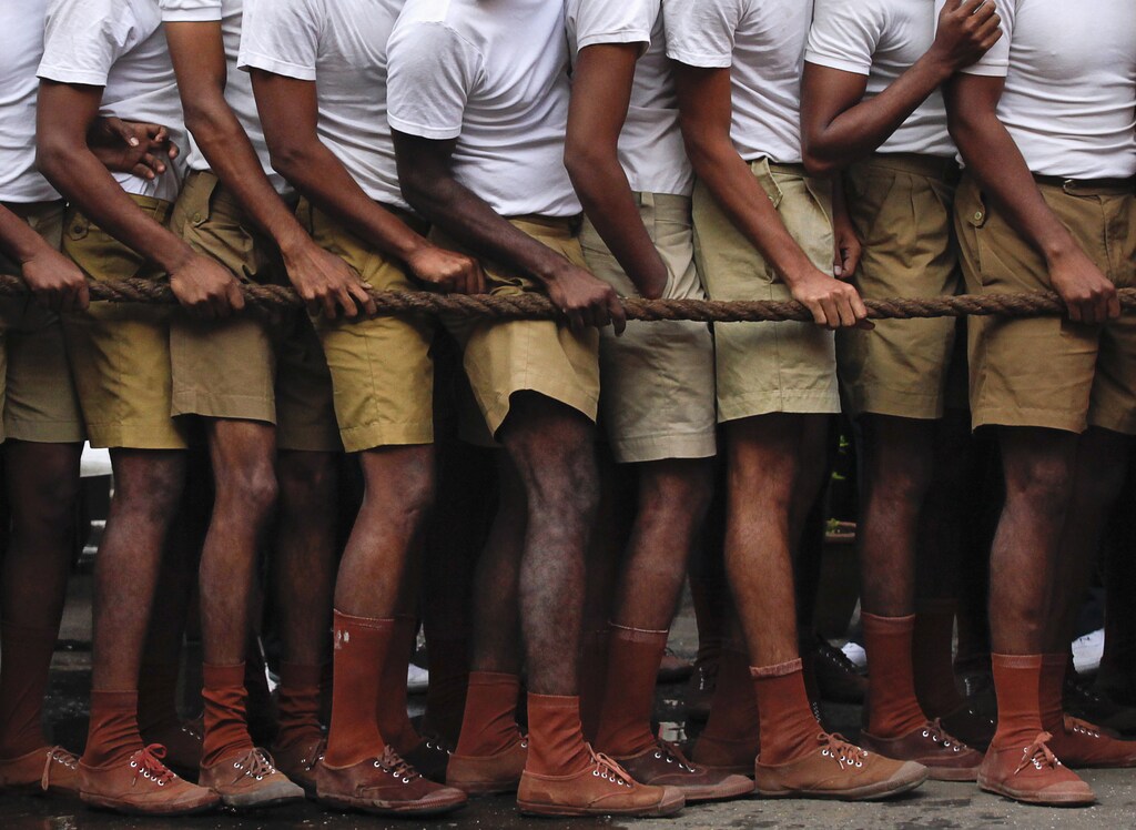 Firefighters hold on to a rope while watching the annual fire drill competition in Mumbai January 9, 2012. Firefighters in Mumbai take part in the annual competition to enhance their emergency response during fire incidents. REUTERS/Danish Siddiqui (INDIA - Tags: SOCIETY) - GM1E8191F4W01