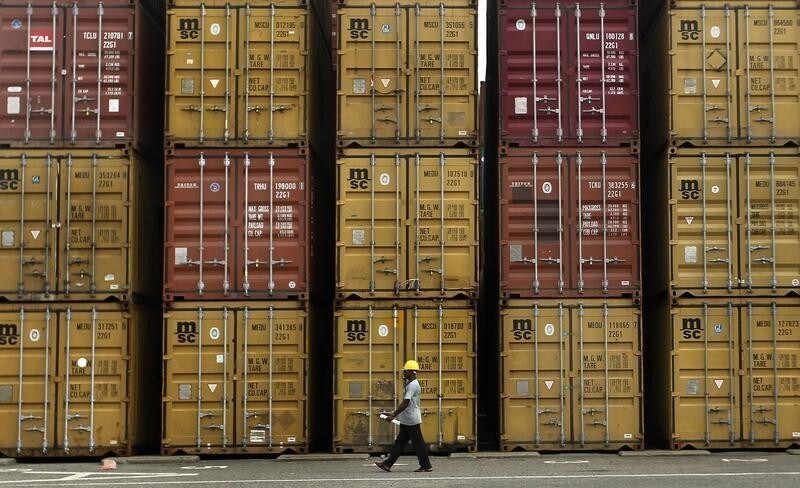A dock worker walks past shipping containers at the main Sri Lankan port in Colombo June 19, 2013.Sri Lanka's rupee edged up on Wednesday due to late dollar sales by exporters on thin volume, with the central bank not intervening in the currency market, but depreciation pressure on the rupee still remains aconcern, said dealers.