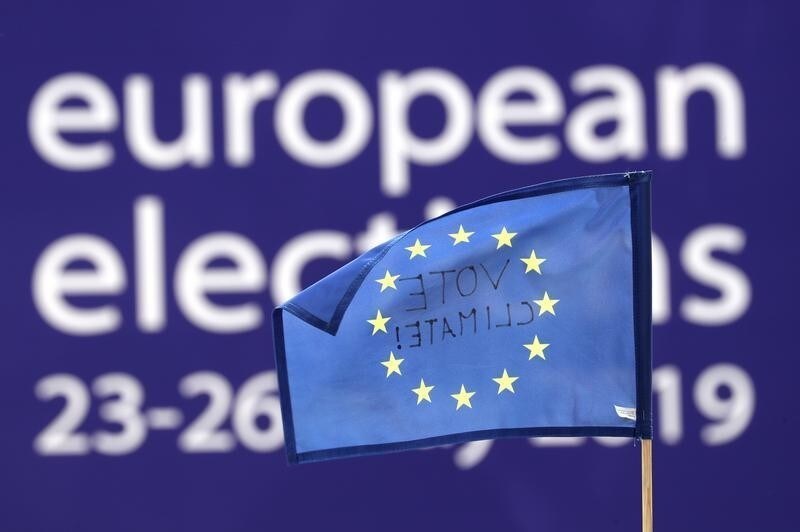 An EU flag with the words "Vote Climate!" is pictured as people demonstrate outside EU Parliament during European Parliament Elections, in Brussels, Belgium May 26, 2019. REUTERS/Yves Herman - RC1520647000