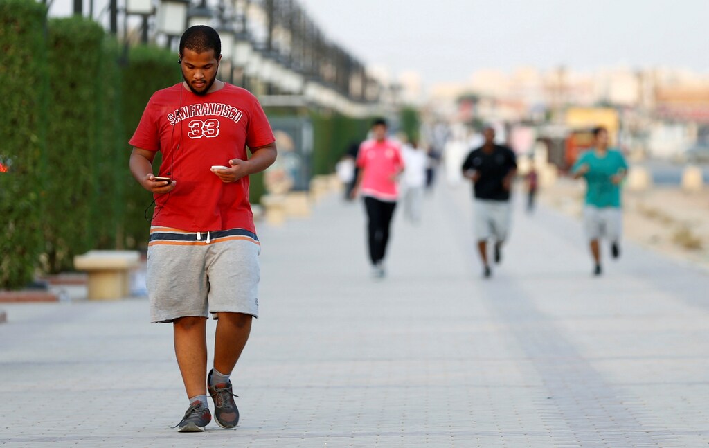 A Saudi man uses his smartphone as he walks on a sidewalk in Riyadh, Saudi Arabia September 21, 2017. REUTERS/Faisal Al Nasser - RC16B5879800