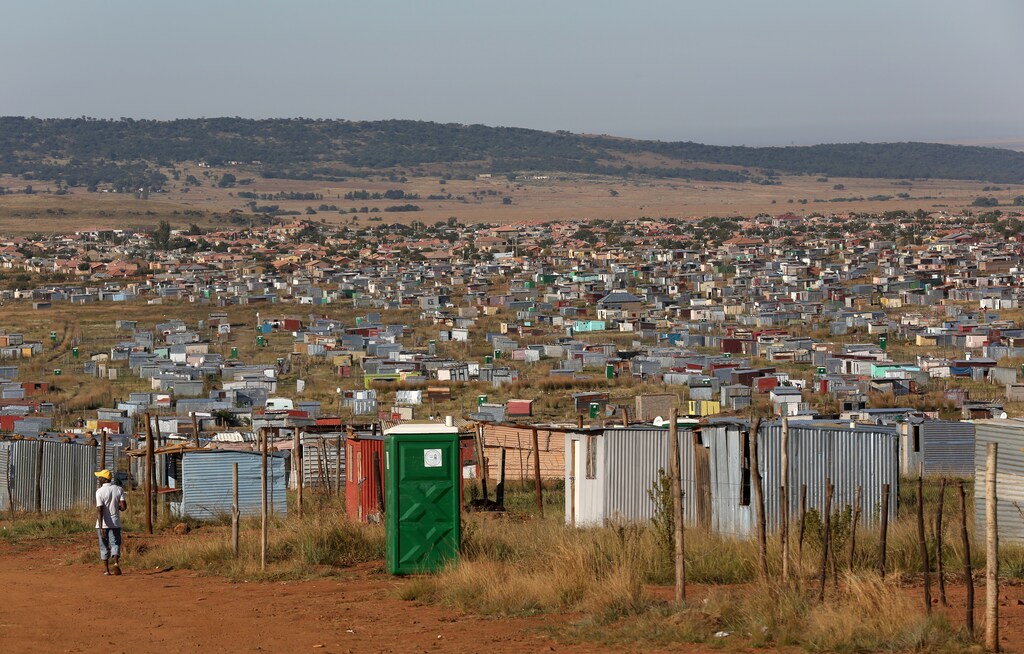 A man walks past a public toilet at Lawley informal settlement in the south of Johannesburg, South Africa, May 2, 2019. Picture taken May 2, 2019. REUTERS/Siphiwe Sibeko - RC11E91AD260