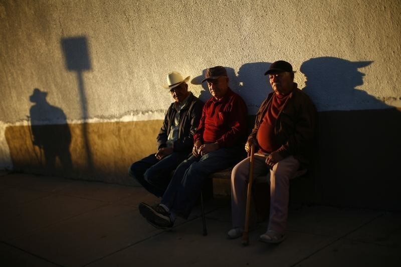 Three men sit on a bench near the fence separating the United States and Mexico in Douglas, Arizona November 10, 2010. Situated in the eastern part of the state, Douglas is a former copper smelting town of more than 18,000 people that lies across the border from Agua Prieta, Mexico. Picture taken November 10, 2010. REUTERS/Eric Thayer (UNITED STATES - Tags: SOCIETY IMAGES OF THE DAY) - GM1E6BH1D8701