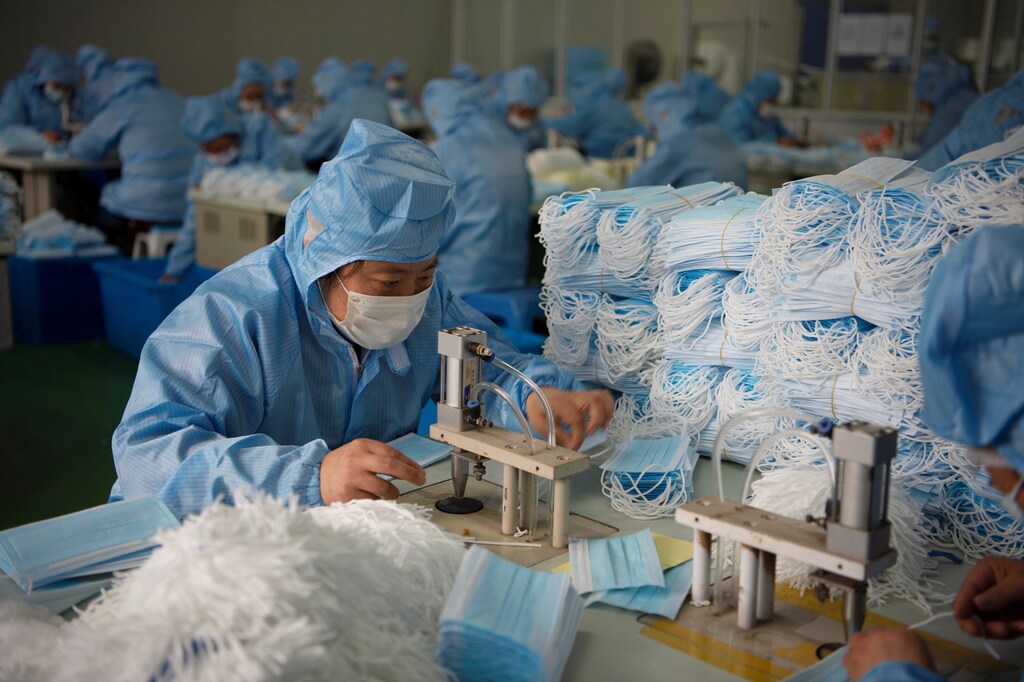 Employees work on a production line for surgical masks at a factory, following an outbreak of the novel coronavirus in the country, in Nantong, Jiangsu province, China February 14, 2020. China Daily via REUTERS ATTENTION EDITORS - THIS IMAGE WAS PROVIDED BY A THIRD PARTY. CHINA OUT. - RC290F9NRWZG