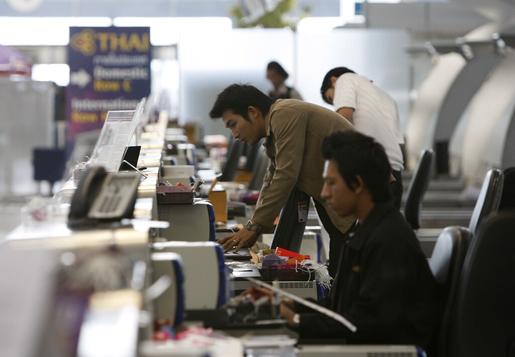 Airport workers start up computers at the check-in counter as anti-government protesters pack up to leave Bangkok's Suvarnabhumi International Airport December 3, 2008.