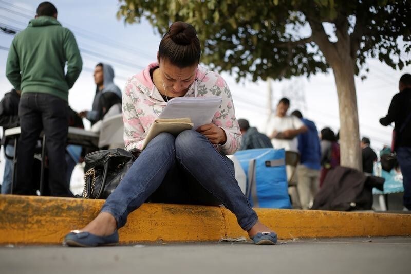 An unemployed woman fills a job application at a parking lot in Ciudad Juarez, Mexico, November 7, 2017. Picture taken November 7, 2017. REUTERS/Jose Luis Gonzalez - RC1FD982FC30