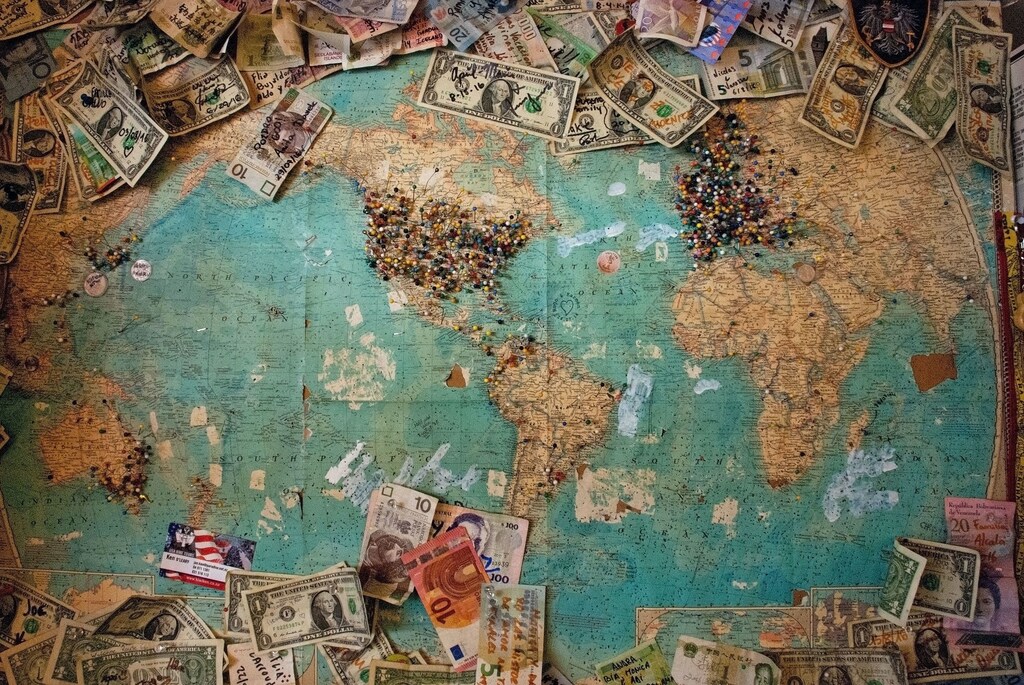 A map with money notes from different countries on it.