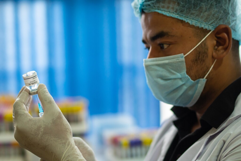 Man filling a syringe with the COVID-19 vaccine