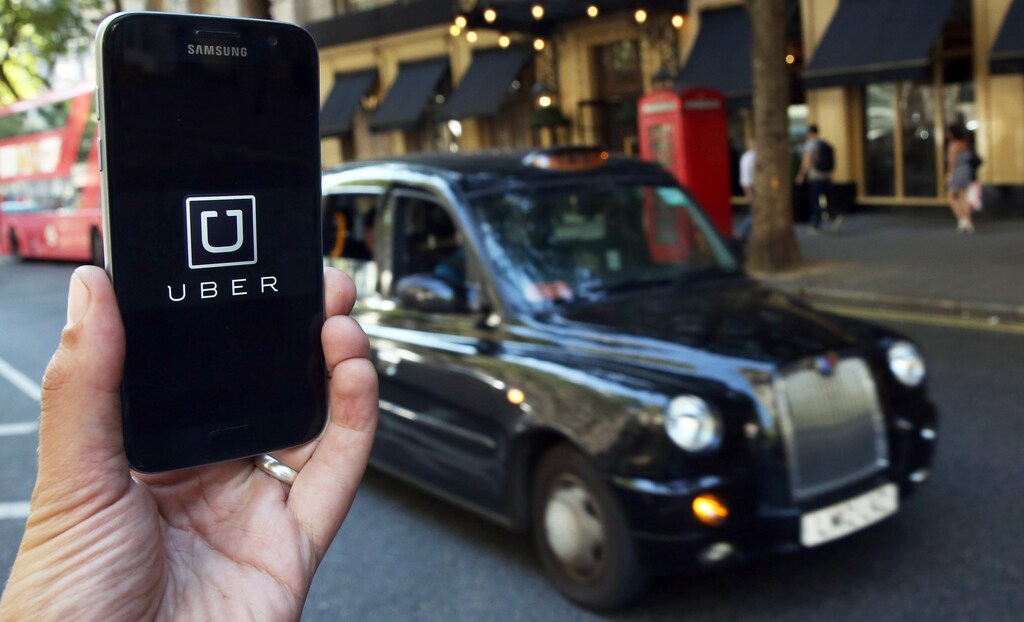A photo illustration shows the Uber app logo displayed on a mobile telephone, as it is held up for a posed photograph in central London, Britain August 17, 2016. REUTERS/Neil Hall/Illustration/File Photo - RTX2P60S