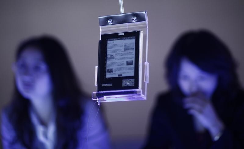Two women stand behind an e-book at the of Frankfurt book fair October 14, 2009. The world's largest book fair with its focal theme on China's literature will run till October 18 in Frankfurt.