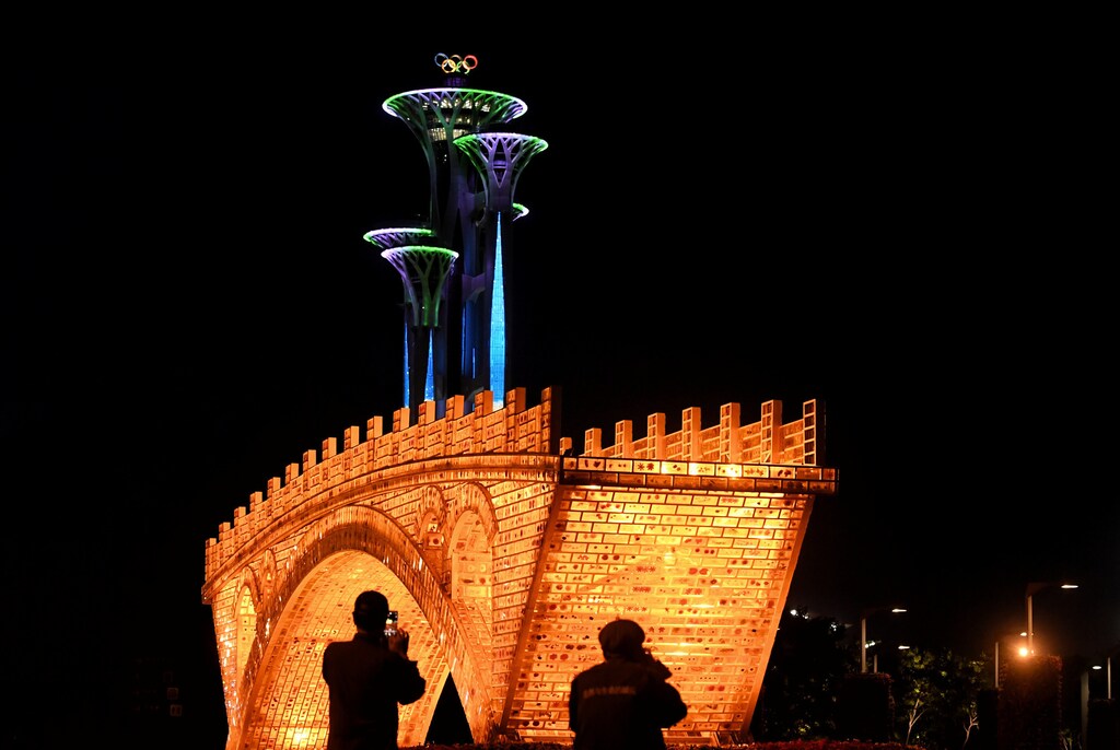 People take pictures in front of a "Golden Bridge on Silk Road" installation, set up ahead of the Belt and Road Forum, outside the National Convention Centre in Beijing, China May 11, 2017. Picture taken May 11, 2017. REUTERS/Stringer ATTENTION EDITORS - THIS IMAGE WAS PROVIDED BY A THIRD PARTY. EDITORIAL USE ONLY. CHINA OUT. - RC19C0AFB5B0