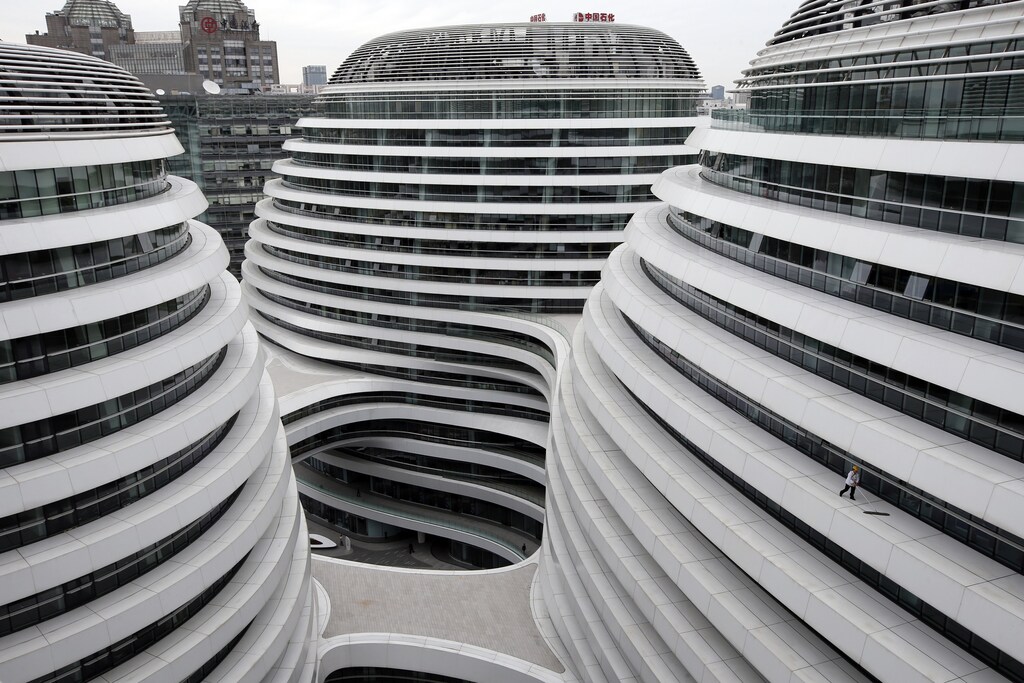 A worker cleans an exterior of a newly built urban complex building accommodating offices and retail shops in Beijing October 14, 2013. REUTERS/Kim Kyung-Hoon (CHINA - Tags: BUSINESS CONSTRUCTION TPX IMAGES OF THE DAY) - GM1E9AE1BGU01
