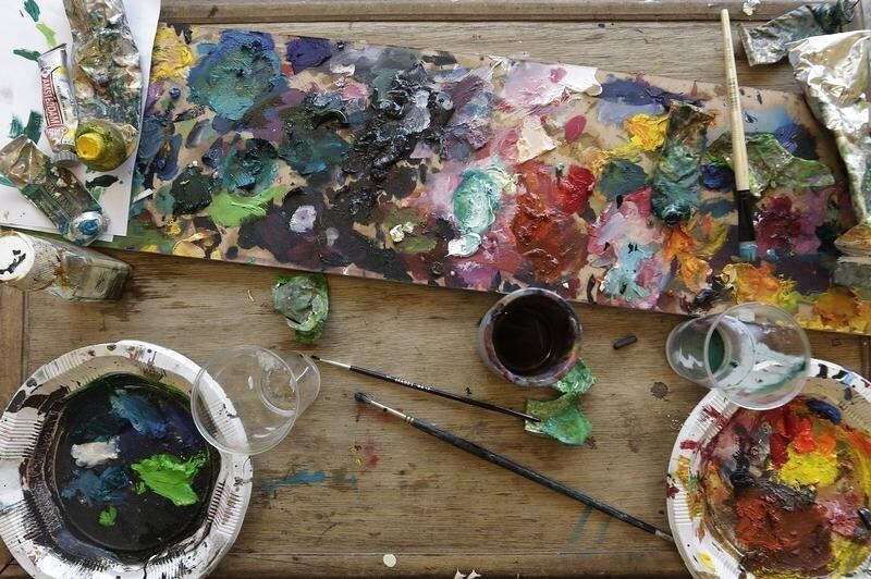 Some paint brushes and a painting palette are pictured in the workshop of French artist Melissa Streicher at the 59 Rivoli aftersquat in Paris February 28, 2013. A hub of counterculture and one of Paris' most visited centres of contemporary art, the 59 Rivoli aftersquat houses 30 workshops on six floors where the public can freely view international artists in the throes of the creative process. Originally a grand branch of Credit Lyonnais bank at No 59 rue de Rivoli, the building lay abandoned for 15 years before being squatted in 1999 by a collective of artists. A deal with current Parisian mayor saw the building bought by the city and rented back to ten visiting creatives and twenty permanent artists, a deal that officials now want to change. The residents are keen to put up a fight against proposals to alter a system they believe is a global example of compromise between squatters and city officials. Picture taken February 28, 2013. REUTERS/Jacky Naegelen (FRANCE - Tags: SOCIETY) - RTX1036B
