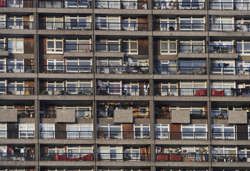A woman sits on her balcony (TOP RIGHT) in a tower block in west London January 22, 2009. Britain entered recession for the first time since 1991 on January 23, 2009 when figures showed output contracted by 1.5 percent in the final three months of 2008. Photograph taken on January 22, 2009. REUTERS/Toby Melville (BRITAIN) - LM1E51N0K1E01