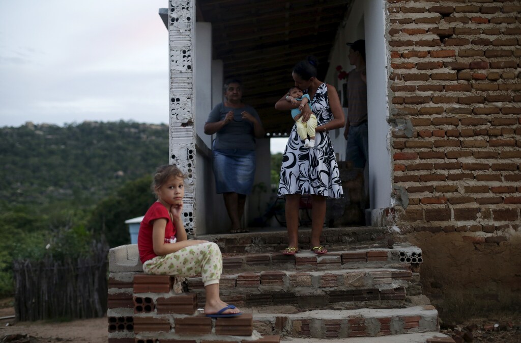 Miriam Araujo, 25, holds Lucas, her 4-months old child born with microcephaly as her mother Joana, 51, observes and her daughter Maisa, 6, looks on, as the stand outside their house, in Sao Jose dos Cordeiros, Brazil February 16, 2016. Picture taken on February 16, 2016.
