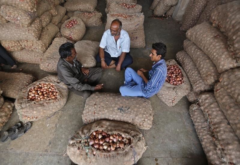 Traders sit amidst stacked sacks, filled with onions and potatoes, at a wholesale vegetable market in the western Indian city of Ahmedabad August 1, 2014. A World Trade Organisation pact to ease worldwide customs rules collapsed late on Thursday over India's demands for concessions on agricultural stockpiling. REUTERS/Amit Dave (INDIA - Tags: BUSINESS FOOD AGRICULTURE) - GM1EA811D7R01