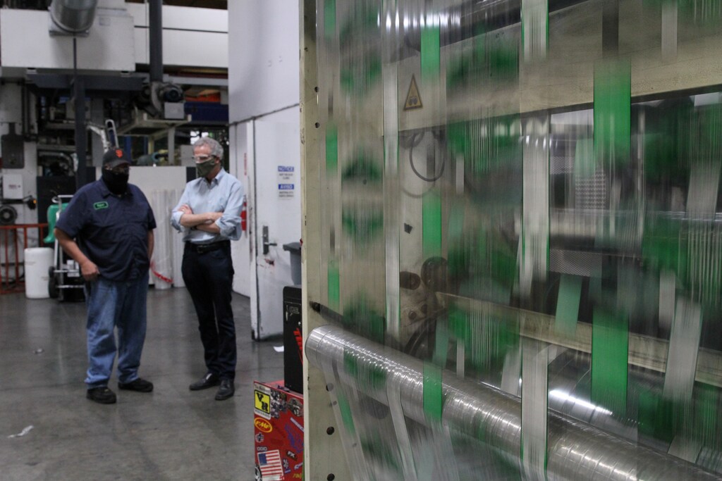 Kevin Kelly, CEO of Emerald Packaging, talks with an employee as they wear protective masks on a production floor of the company, which prints packaging material to be used for produce, amid the coronavirus disease (COVID-19) outbreak, in Union City, California, U.S. on May 7, 2020. Picture taken May 7, 2020. REUTERS/Nathan Frandino - RC21PG9H6SW7