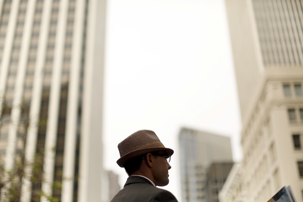 A man wearing a hat looks over the skyline of San Francisco, California March 20, 2015. REUTERS/Robert Galbraith - RTR4U82A