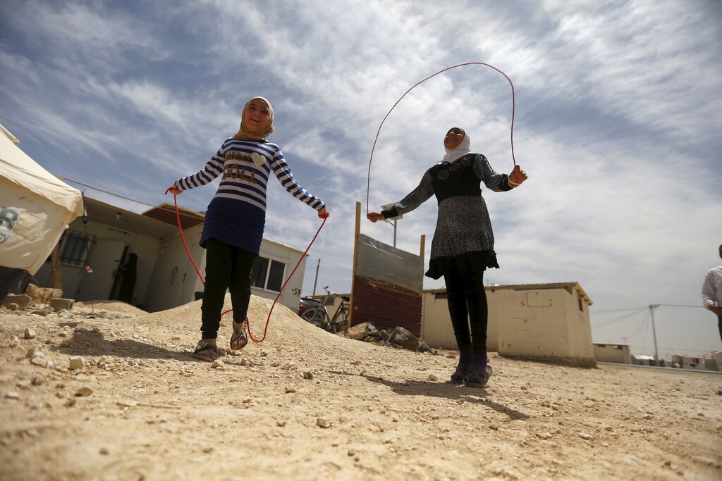 Syrian refugee Omayma al Hushan (R), 14, who launched an initiative against child marriage among Syrian refugees, plays with her friend outside their residence in Al Zaatari refugee camp in the Jordanian city of Mafraq, near the border with Syria, April 21, 2016.