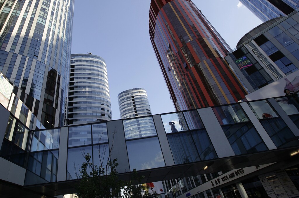 A woman walks between buildings at Sanlitun SOHO residential and commercial complex in Beijing May 12, 2011.