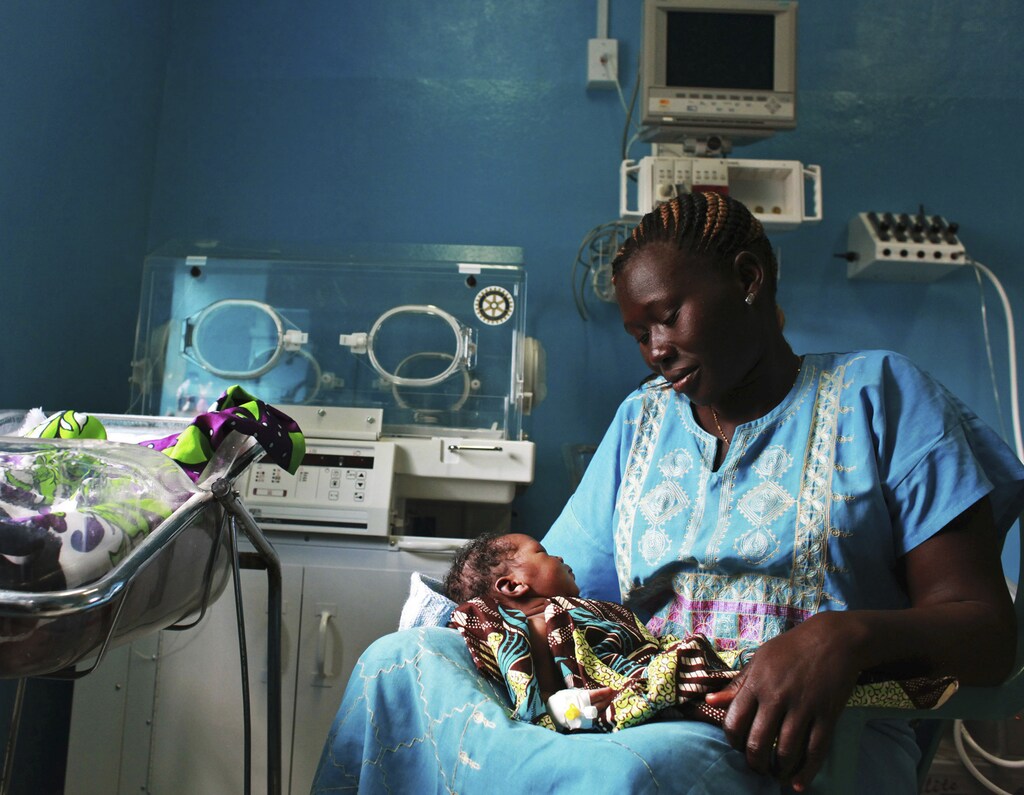 A woman holds her newborn baby in a nursery at the Juba Teaching Hospital in Juba April 3, 2013. Very few births in South Sudan, which has the highest maternal mortality rate in the world at 2,054 per 100,000 live births, are assisted by trained midwives, according to the UNDP's website. Picture taken April 3, 2013. REUTERS/Andreea Campeanu (SOUTH SUDAN - Tags: SOCIETY HEALTH) - RTXY7QJ