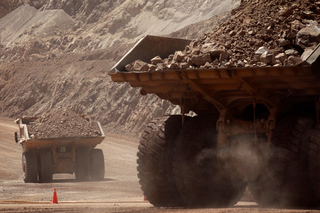 Mining trucks travel along a road at Chile's Esperanza copper mine near Calama town.