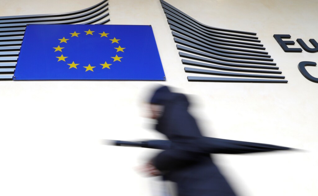 A woman walks past the European flag outside the EU Commission headquarters in Brussels, Belgium March 1, 2017. REUTERS/Yves Herman - RTS10X7H
