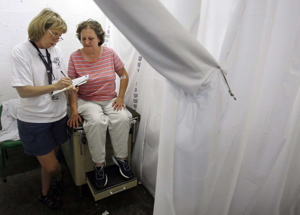 Una paciente conversa con una médica durante una consulta en la clínica gratuita Remote Area Medical (RAM) en Wise, Virginia, el 25 de julio de 2009: Los problemas de salud de las mujeres han sido sistemáticamente desatendidos.