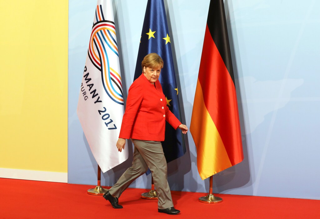 German Chancellor Angela Merkel walks past flags as she arrives before greeting heads of State at the start of the G20 leaders summit in Hamburg, Germany, July 7, 2017. REUTERS/Ludovic Marin/Pool - RC1F3C95F030
