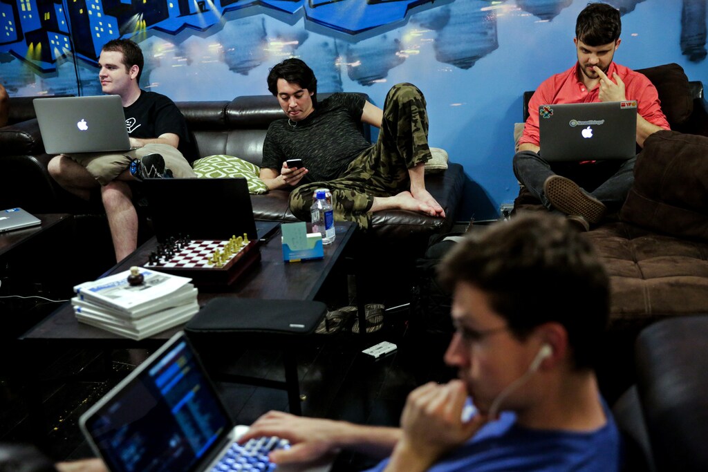 Zander Dejah (2nd L), 25, who works as a Virtual Reality engineer, Nick Olszowy (C), 25, a software engineer and Andrew Bresee, 26, a software engineer, all who are residents of The Negev tech house, use their electronics during a Sunday "family" dinner in San Francisco, California, U.S. October 30, 2016. SEARCH "LURIE TECH" FOR THIS STORY. SEARCH "WIDER IMAGE" FOR ALL STORIES. - RTS12CIT