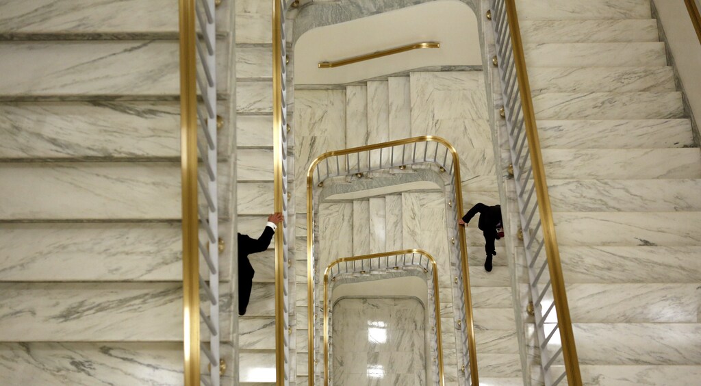 Two men hold onto the bannister as they ascend a staircase in the Rayburn House Office Building on Capitol Hill in Washington April 24, 2013. REUTERS/Kevin Lamarque (UNITED STATES - Tags: POLITICS SOCIETY) - RTXYYBD