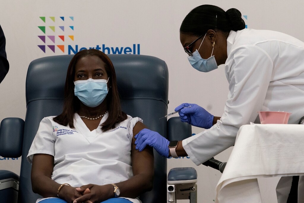 Sandra Lindsay, a nurse at Long Island Jewish Medical Center, is inoculated with the coronavirus disease (COVID-19) vaccine by Dr. Michelle Chester from Northwell Health at Long Island Jewish Medical Center in New Hyde Park, New York, U.S., December 14, 2020. Mark Lennihan/Pool via REUTERS TPX IMAGES OF THE DAY - RC23NK9TD83S