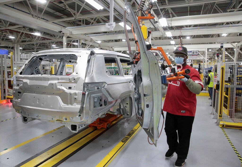 a worker assembles a car in a factory