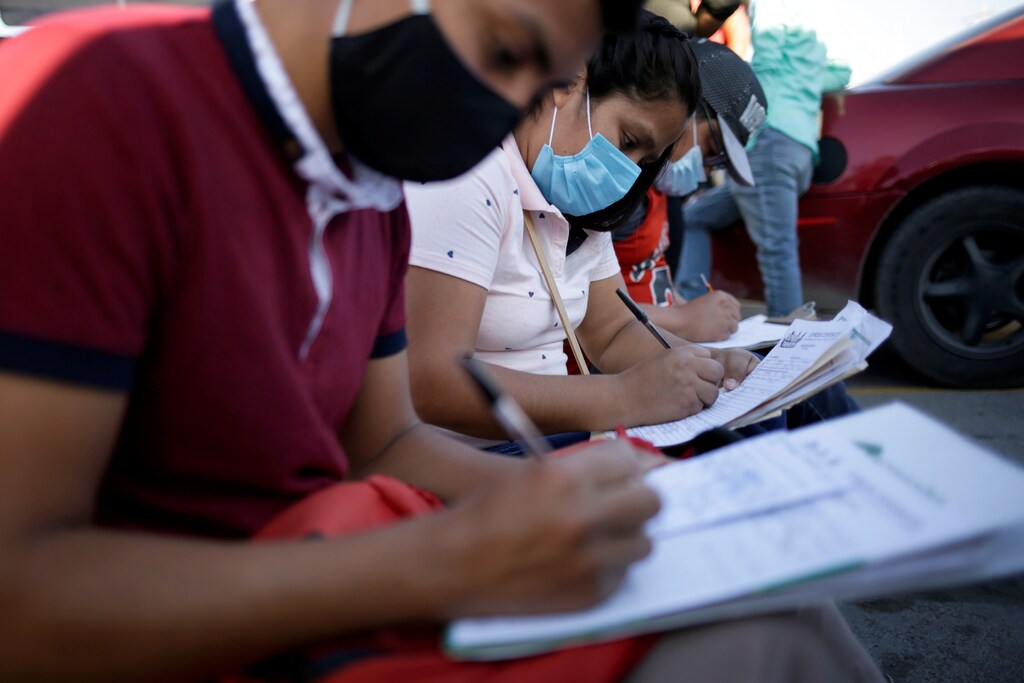 Job seekers fill out job application forms for assembly factories as the coronavirus disease (COVID-19) outbreak continues in Ciudad Juarez, Mexico June 17, 2020. Picture taken June 17, 2020. REUTERS/Jose Luis Gonzalez - RC2VJH9DJJPC