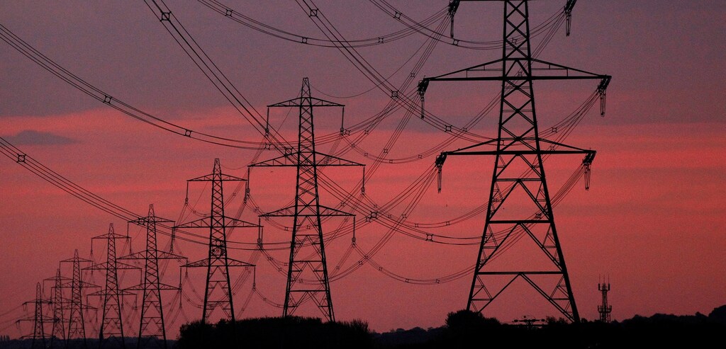 The sun rises behind electricity pylons near Chester, northern England, October 24, 2011.