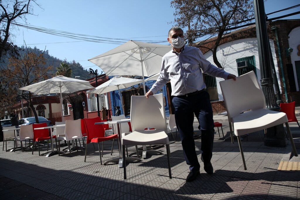 A man arranges furniture at a restaurant preparing to reopen as Chile's government allows outdoor servicing in restaurants after easing some lockdown measures put in place during the coronavirus disease (COVID-19) outbreak, in Santiago, Chile August 31, 2020. REUTERS/Ivan Alvarado - RC27PI9JK9XW